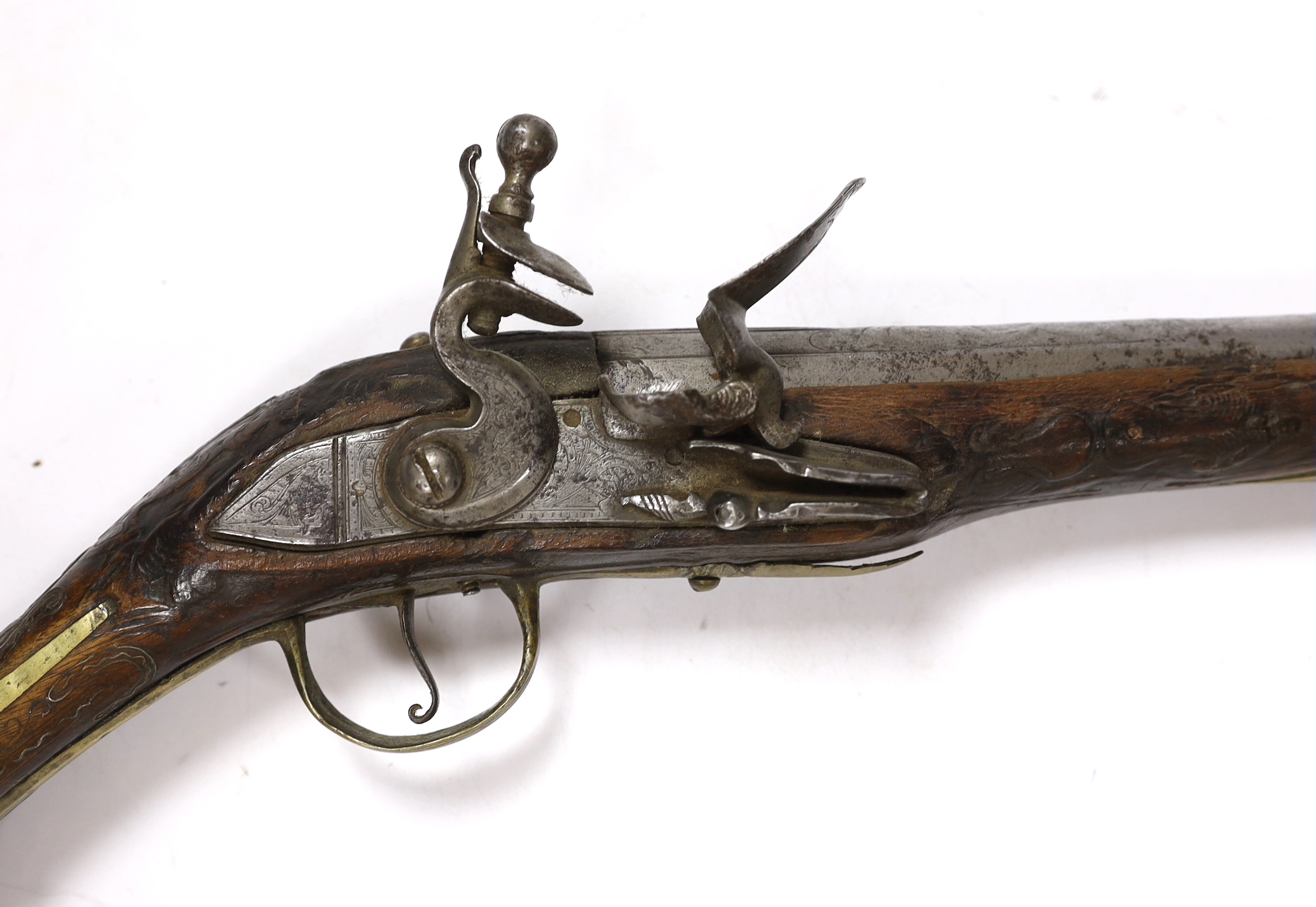 A Turkish Flintlock holster pistol with brass mounts, long spur butt cap, engraved lock and carved stock, barrel 29.5cm